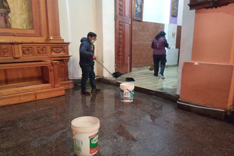 Fieles apoyaron en sacar agua de la capilla.