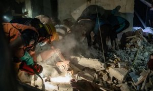 Palestinos buscan personas desaparecidas bajo los escombros de una casa tras un ataque aéreo israelí en el campo de refugiados de Rafah.