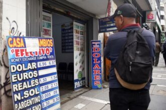 Una persona mira los carteles de una casa de cambio.