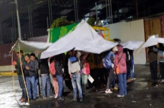 Pobladores de La Unión esperan bajo la lluvia.