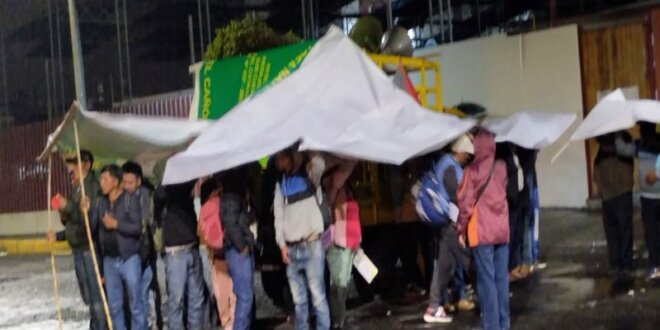 Pobladores de La Unión esperan bajo la lluvia.