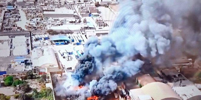 Bomberos combaten incendio en almacén de desechos.